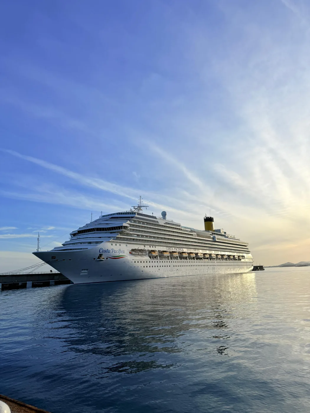 Large cruise ship berthed in port beneath a blue evening sky