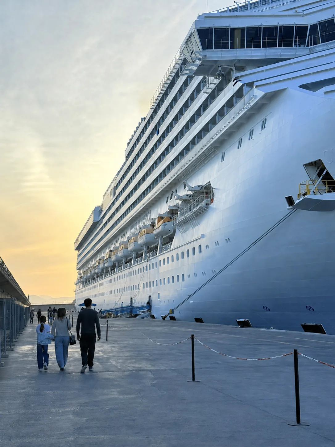 Large cruise ship berthed in port beneath a blue evening sky
